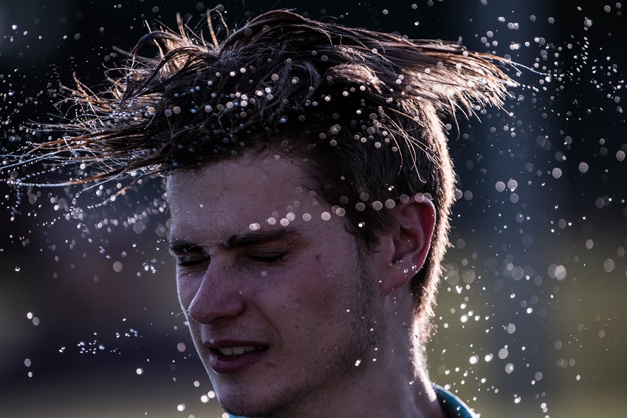 a-man-splashing-water-off-his-hair