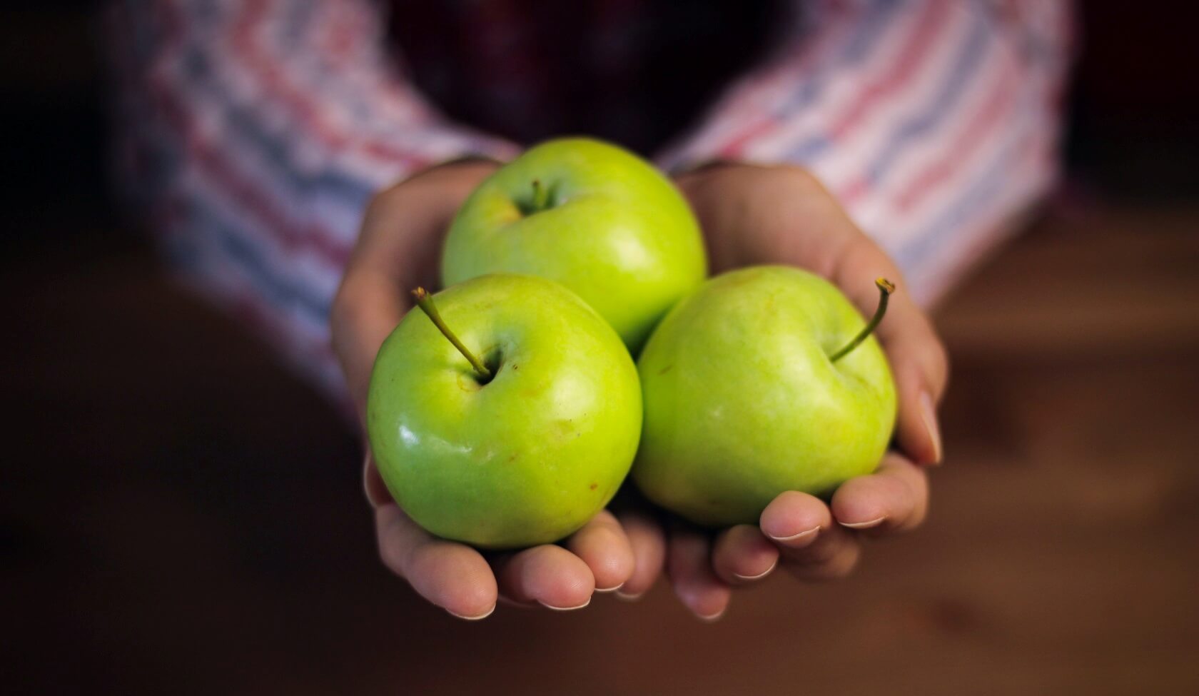 ثلاث تفاحات خضراء في متناول اليد تمثل صحة القلب